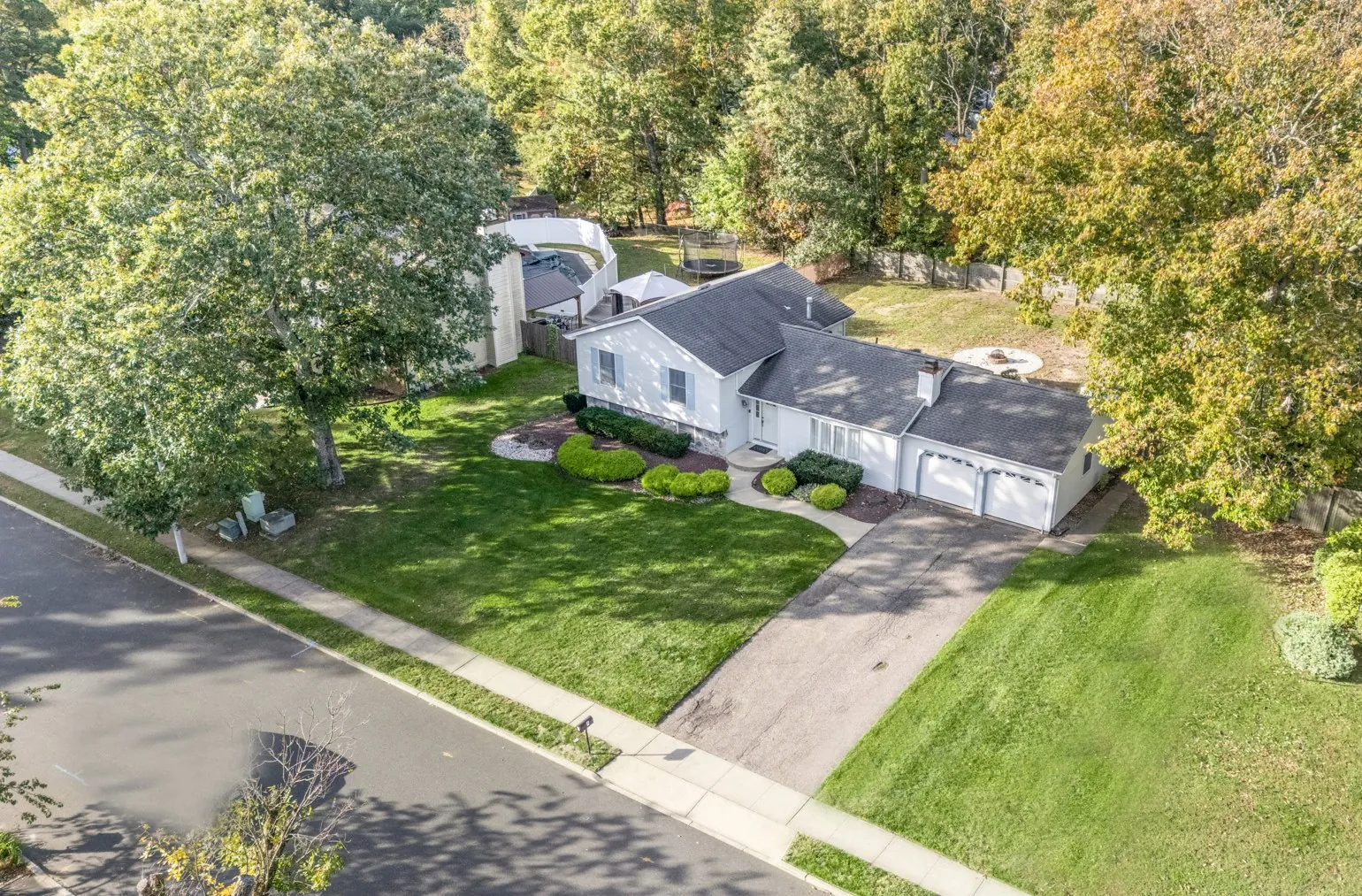 Aerial view of the home and surrounding street and trees