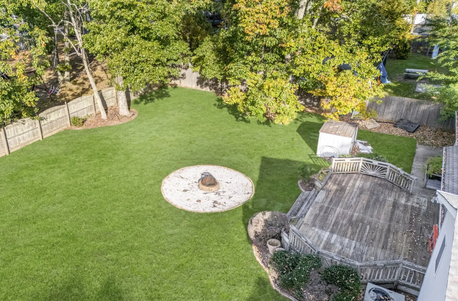 Aerial view of the backyard with lawn, fire-pit area and deck