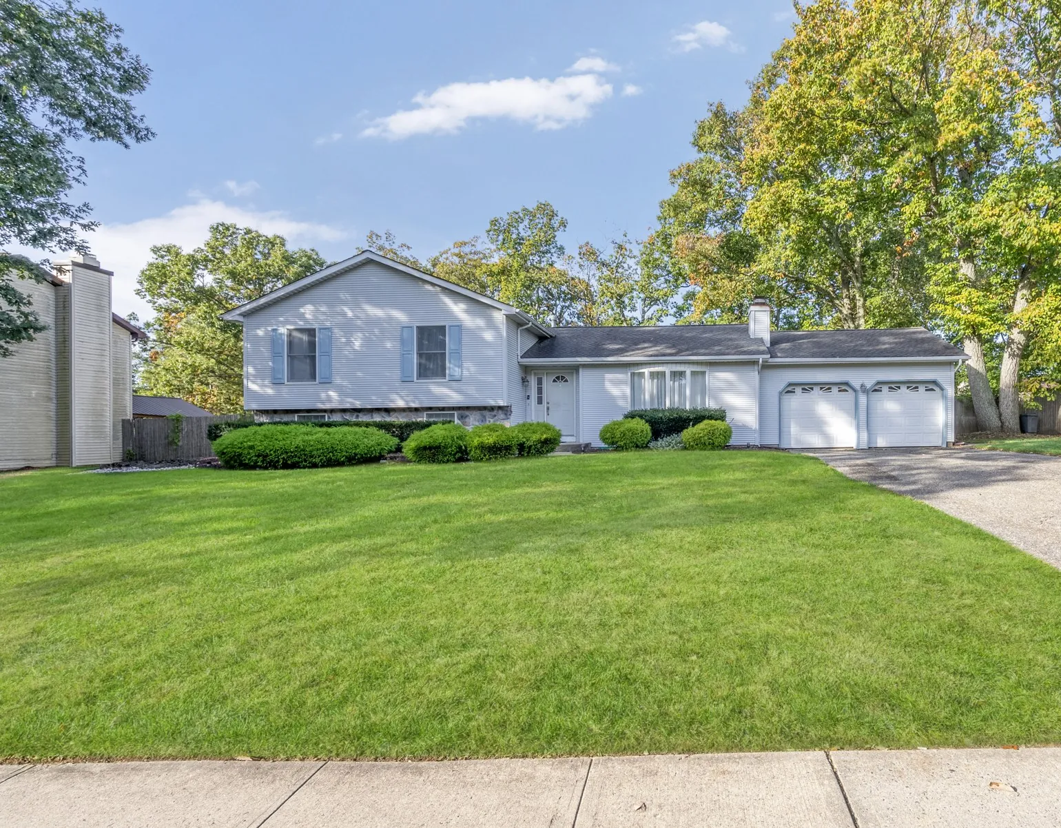 Front exterior of 4 Hickory Hill Rd, a split-level home with a green front lawn
